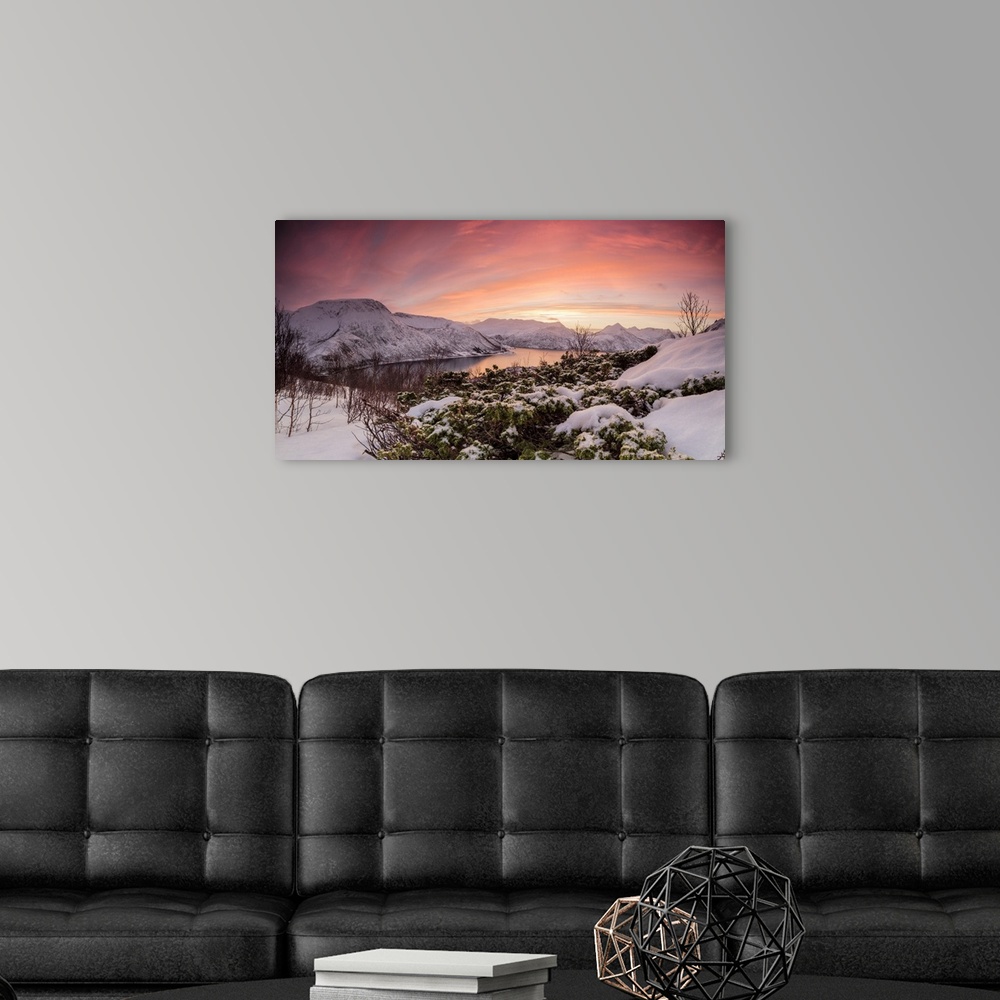 A modern room featuring Panorama of frozen sea surrounded by snow framed by the orange sky at sunset, Torsken, Senja, Tro...