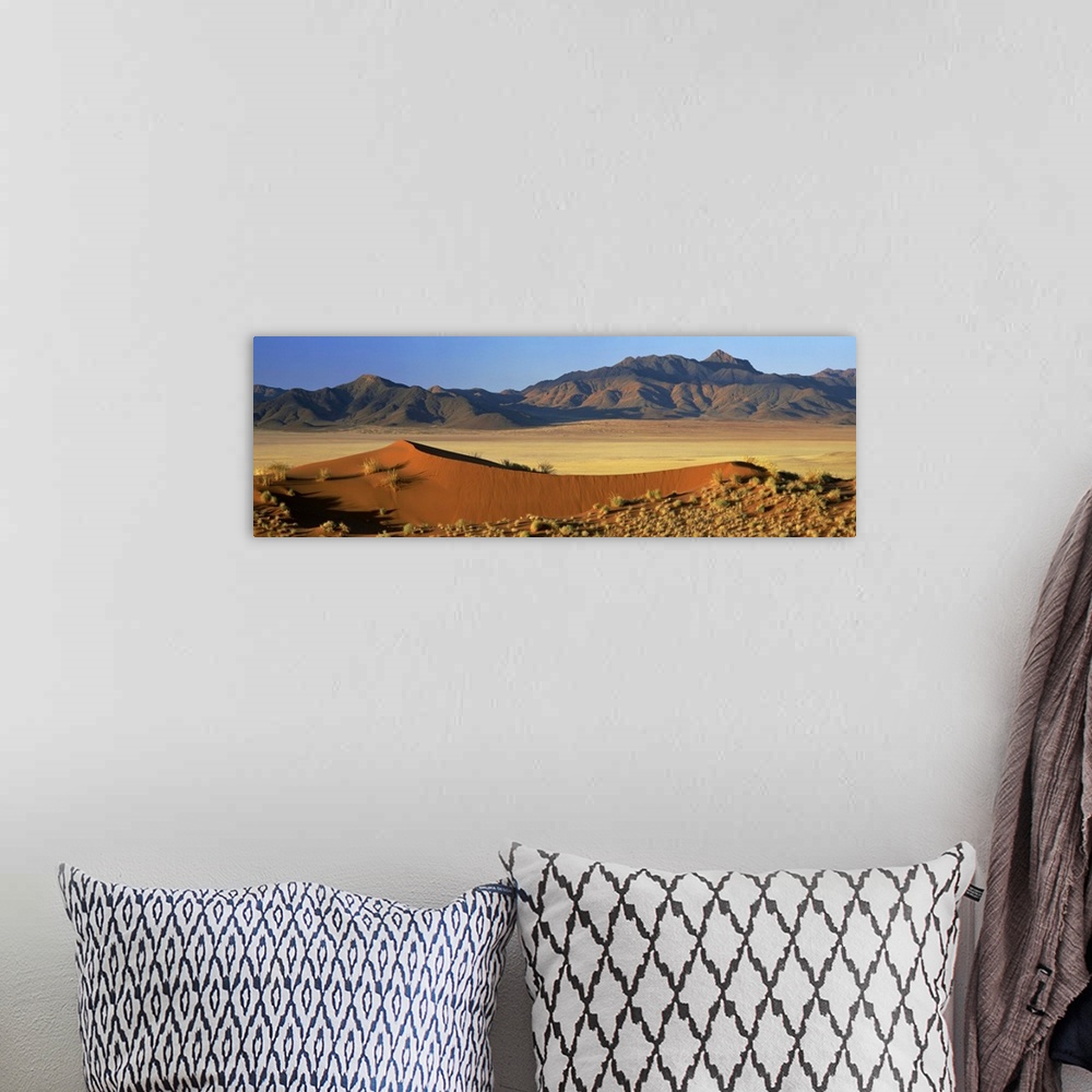 A bohemian room featuring Panoramic view over orange sand dunes towards mountains, Namibia, Africa