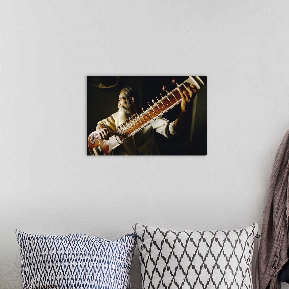 A bohemian room featuring Portrait of an elderly man playing the sitar, India