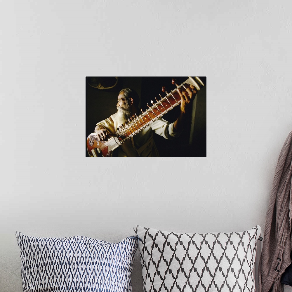 A bohemian room featuring Portrait of an elderly man playing the sitar, India