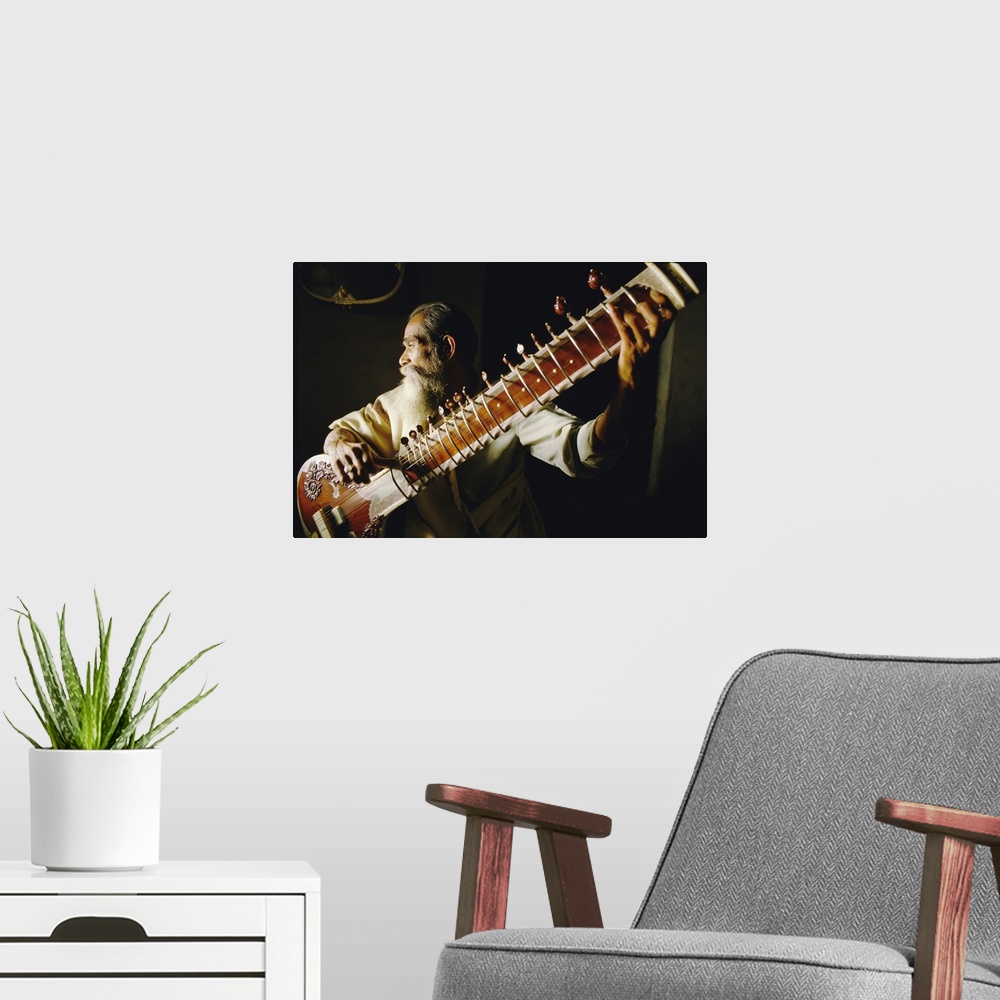 A modern room featuring Portrait of an elderly man playing the sitar, India