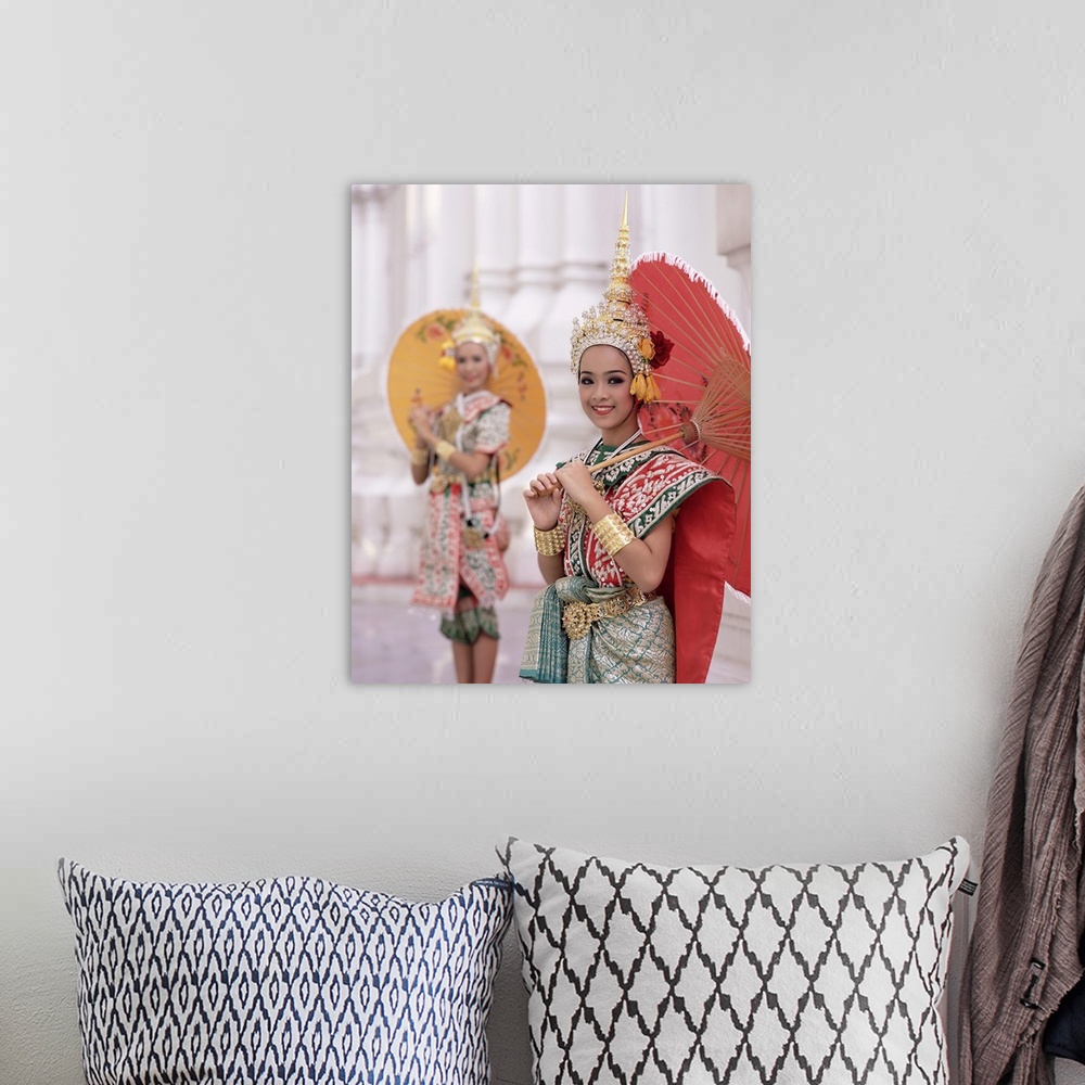 A bohemian room featuring Portrait of two dancers in traditional Thai classical dance costume, smiling and looking at the c...