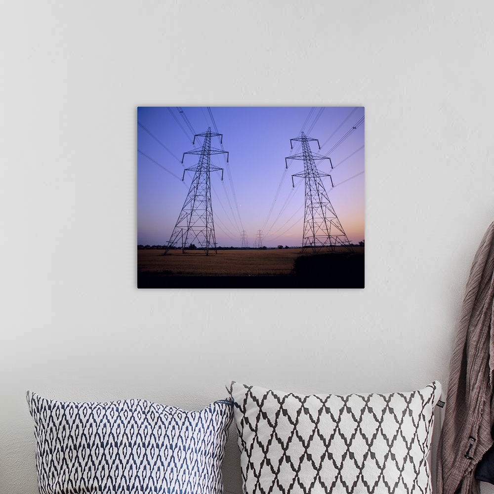A bohemian room featuring Pylons in a rural landscape at dusk