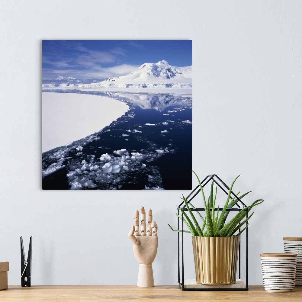 A bohemian room featuring Reflections in icy sea of snow covered mountain, Antarctica