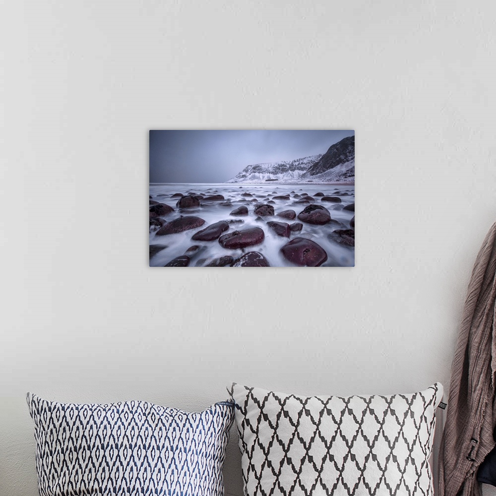 A bohemian room featuring Rocks on the beach modeled by the wind surround the icy sea, Unstad, Lofoten Islands, Arctic, Nor...