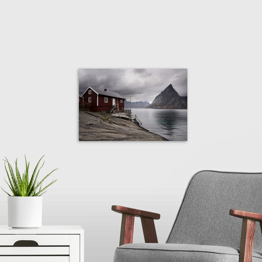 A modern room featuring Rorbuer (fishermen's huts) on fjord with mountains, Lofoten Islands, Norway, Scandinavia