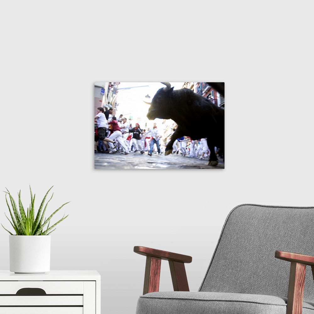 A modern room featuring A bull in motion chasing a blurry crowd. The motion blur effect suggests a sense of speed or conv...