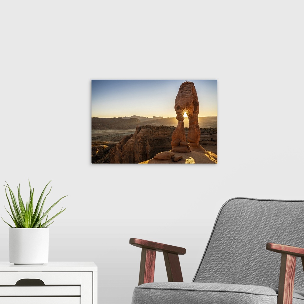 A modern room featuring Setting sun through Delicate Arch with sunburst, Arches National Park, Utah, United States of Ame...