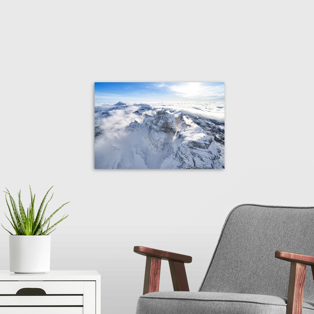 A modern room featuring Snow capped Monte Pelmo emerging from clouds, aerial view, Dolomites, Belluno province, Veneto, I...