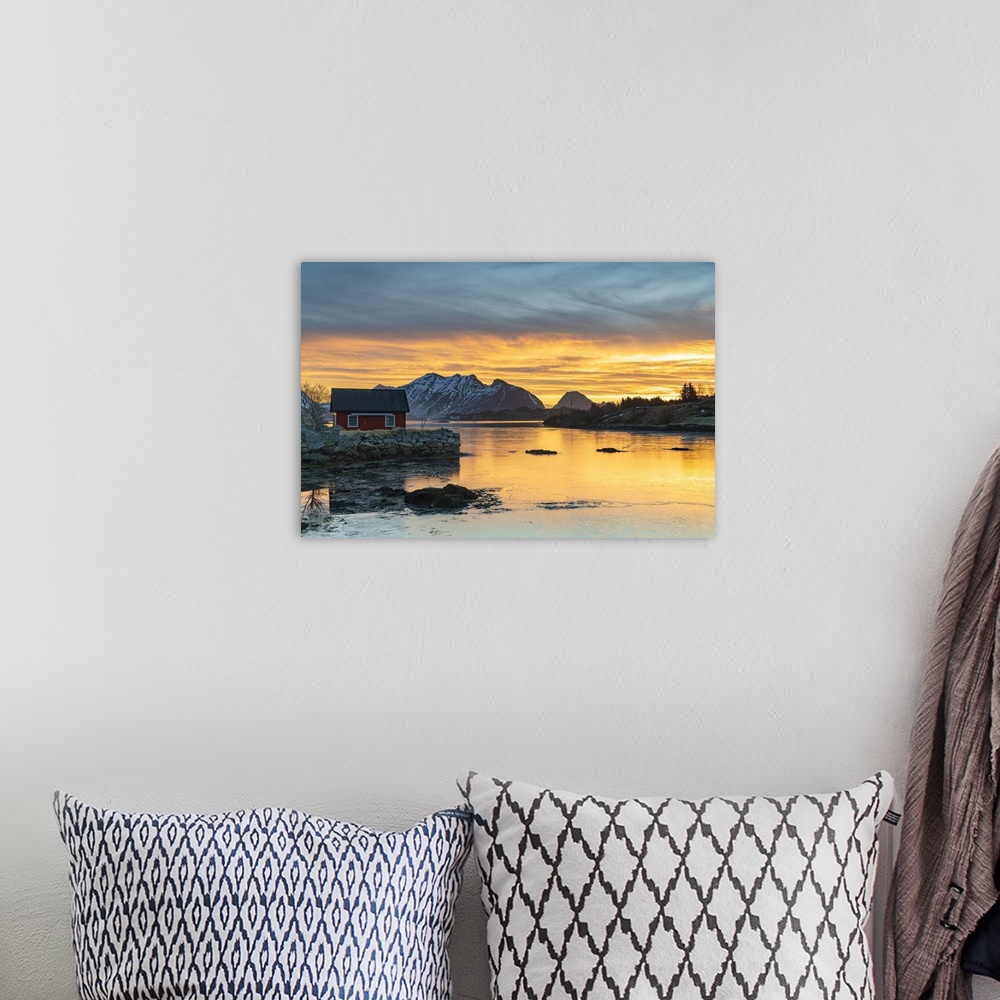 A bohemian room featuring Snowcapped mountains and fisherman's red cabin under the burning sky at dawn, Ballstad, Vestvagoy...