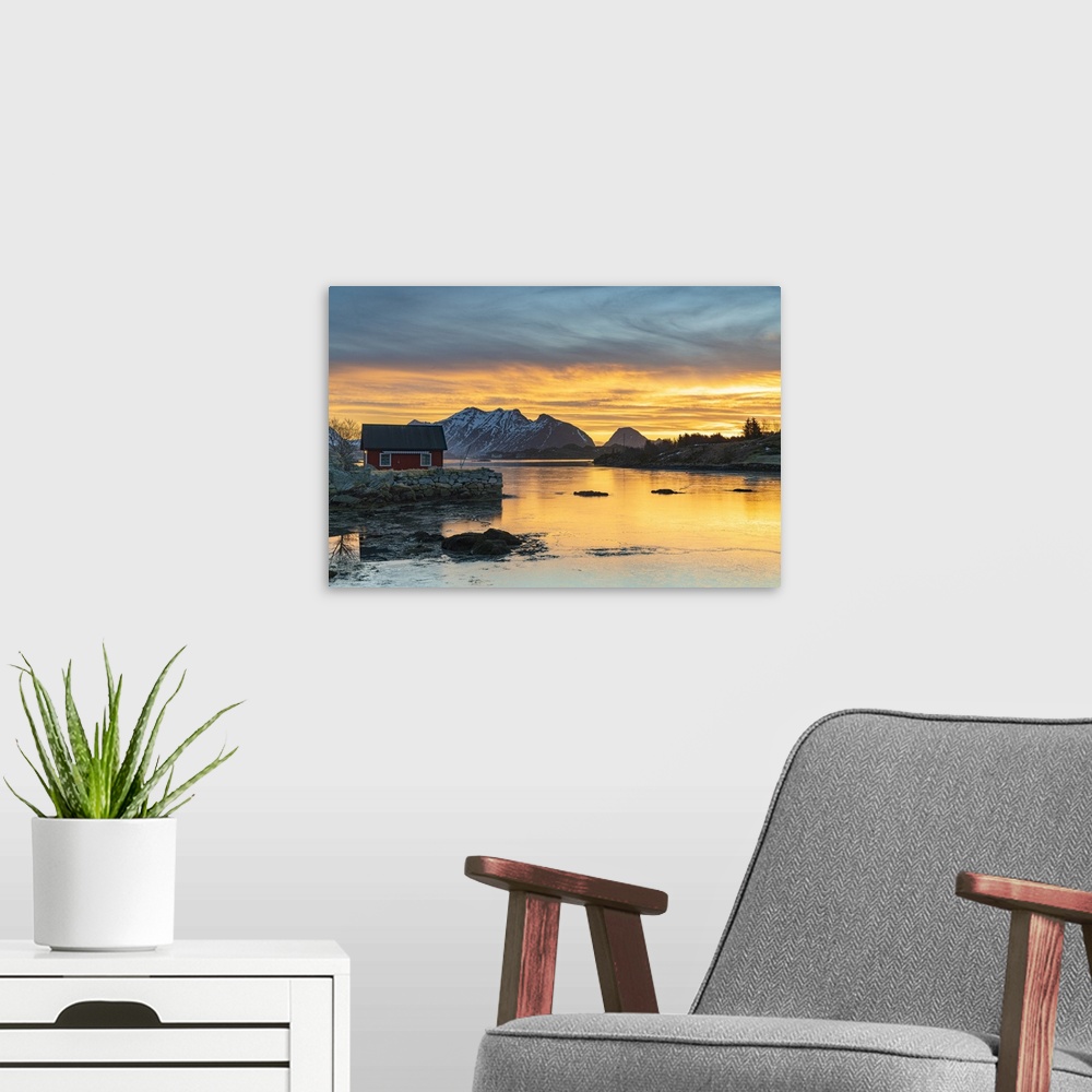 A modern room featuring Snowcapped mountains and fisherman's red cabin under the burning sky at dawn, Ballstad, Vestvagoy...
