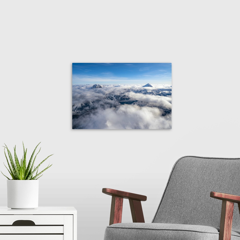 A modern room featuring Sorapis group and Antelao emerging from clouds, aerial view, Dolomites, Belluno province, Veneto,...