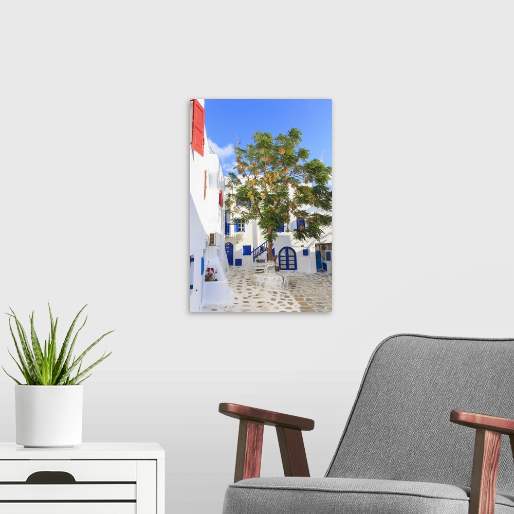 A modern room featuring Square with blossoming tree, whitewashed buildings, blue sky, Mykonos Town, Mykonos, Cyclades, Gr...