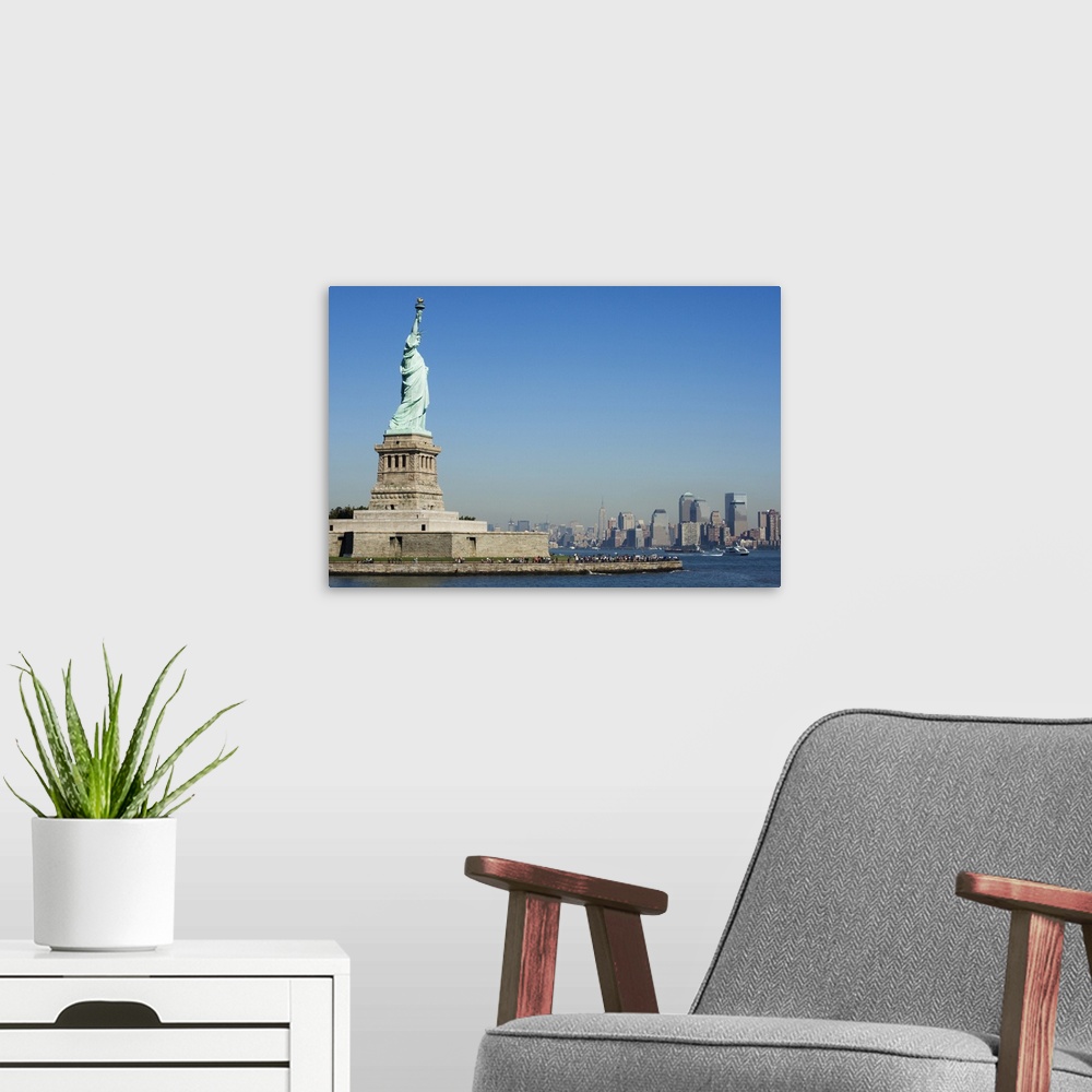 A modern room featuring Statue of Liberty, Liberty Island and Manhattan skyline beyond, New York City, New York