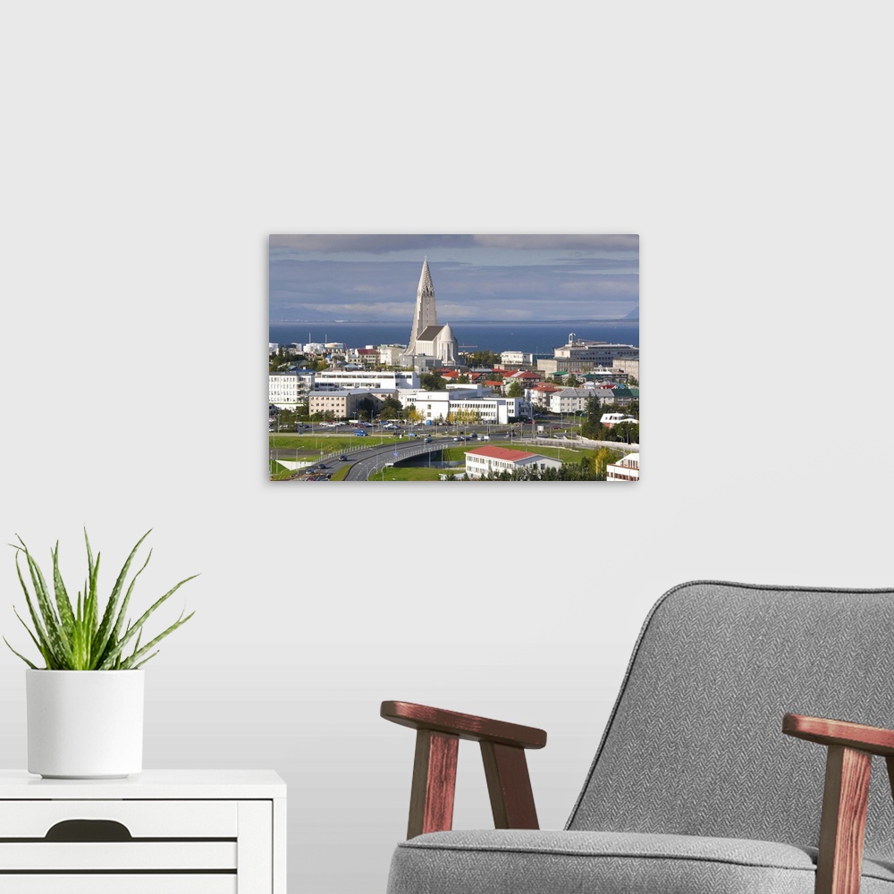A modern room featuring The 75m tall steeple and vast modernist church of Hallgrimskirkja, rising above the city, built b...