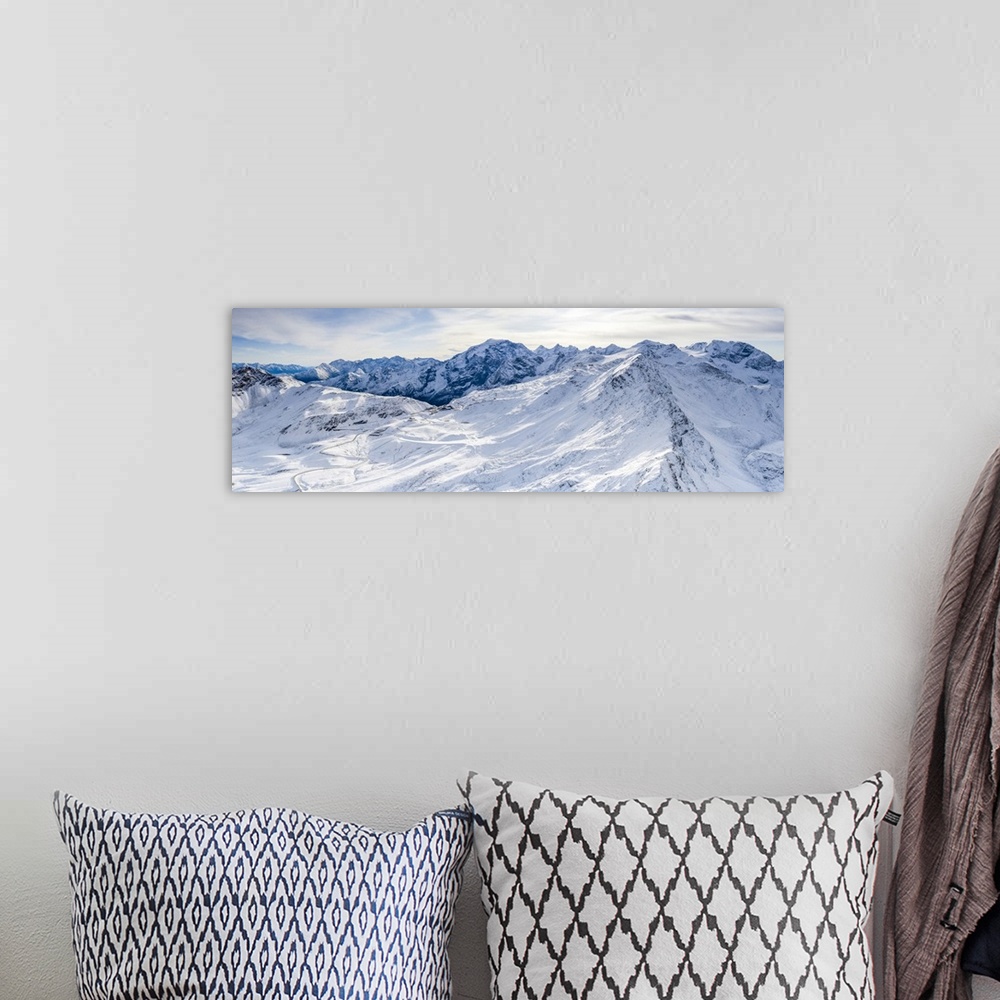 A bohemian room featuring Aerial view by drone of Stelvio Pass road and snowy Ortles mountain, Sondrio province, Valtellina...