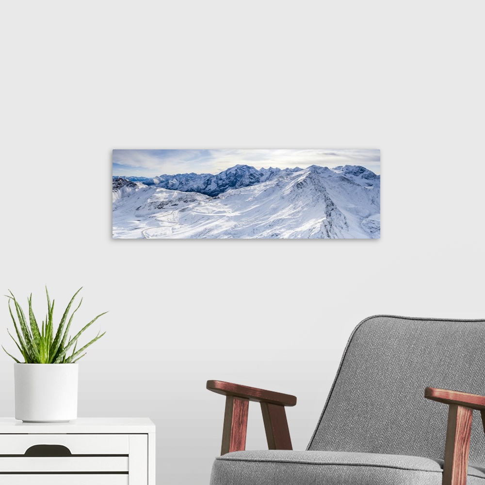 A modern room featuring Aerial view by drone of Stelvio Pass road and snowy Ortles mountain, Sondrio province, Valtellina...