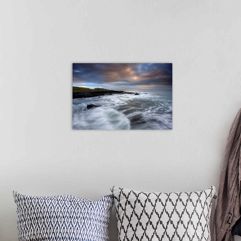 A bohemian room featuring Stormy day with ruins of Dunstanburgh Castle, Northumberland, England