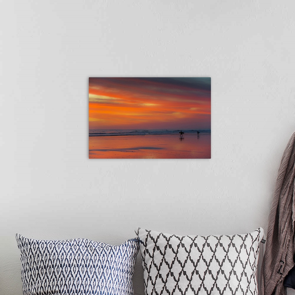 A bohemian room featuring Surfer silhouetted on Guiones Beach where many come to relax and surf at sunset, Playa Guiones, N...