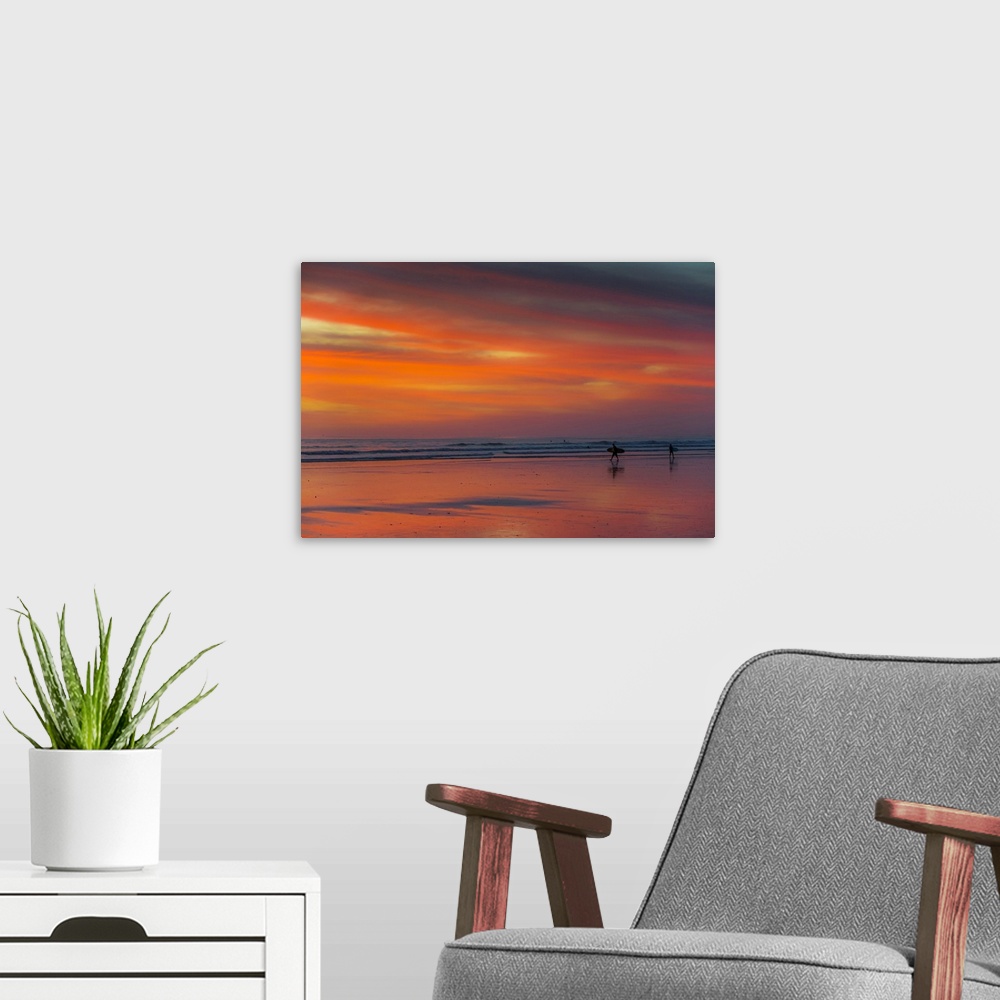 A modern room featuring Surfer silhouetted on Guiones Beach where many come to relax and surf at sunset, Playa Guiones, N...