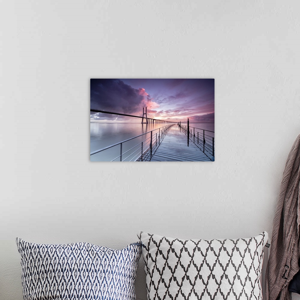 A bohemian room featuring Sunrise colors the clouds reflected in Tagus River and frame the Vasco da Gama bridge in Lisbon, ...