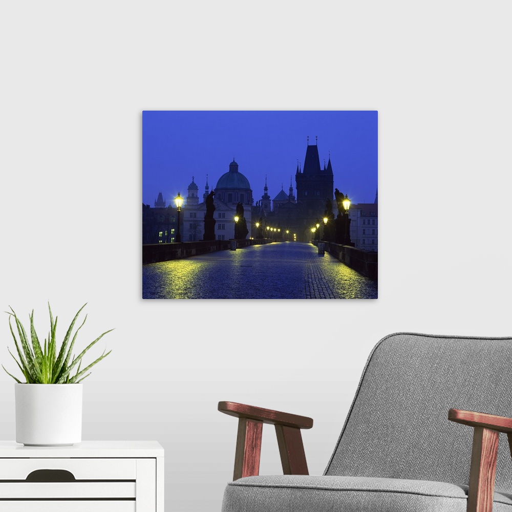 A modern room featuring The Charles Bridge at night and city skyline with spires, Prague, Czech Republic