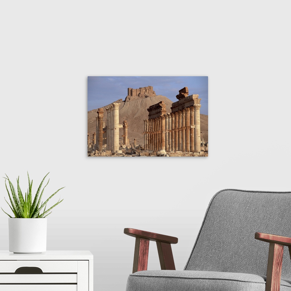 A modern room featuring The Great Colonnade, with Arab castle on hill in background, Palmyra, Syria