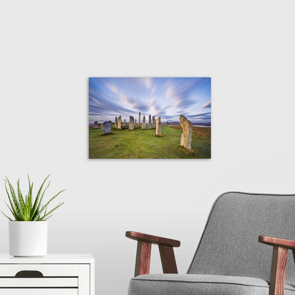 A modern room featuring The Lewisian gneiss stone circle at Callanish on an early autumnal morning with clouds forming ab...
