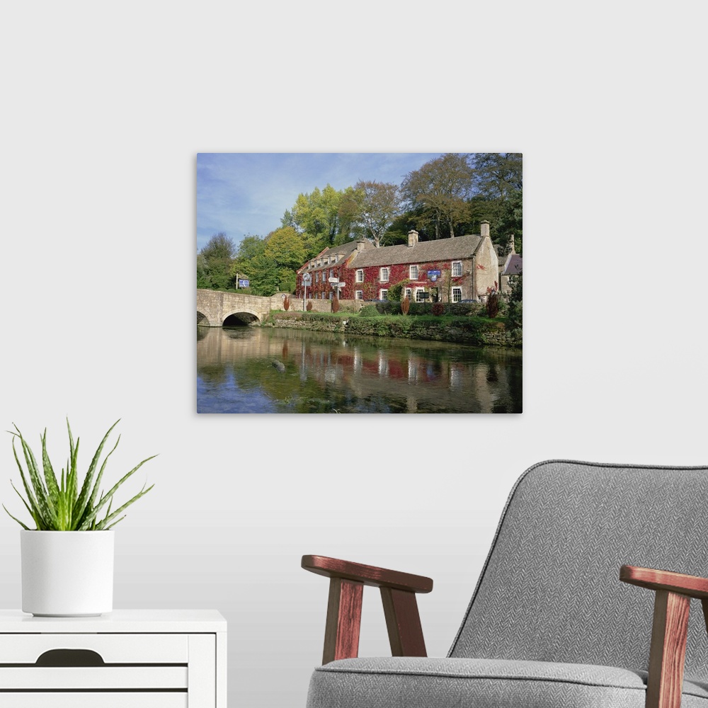 A modern room featuring The Swan Hotel reflected in the river at Bibury, Gloucestershire, England