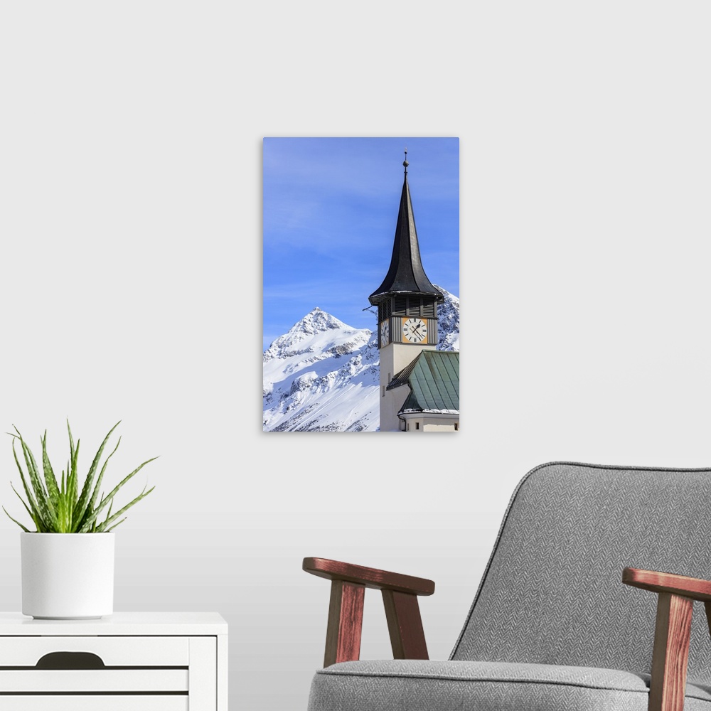 A modern room featuring The typical alpine bell tower frames the snowy peaks, Langwies, district of Plessur, Canton of Gr...