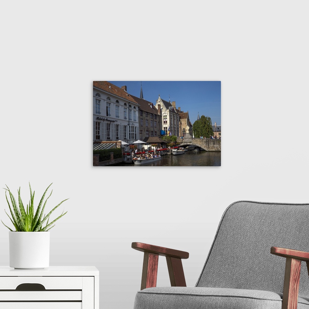 A modern room featuring Tourists in boats travel on the Den Dijver canal in summer, Bruges, West Flanders, Belgium, Europe
