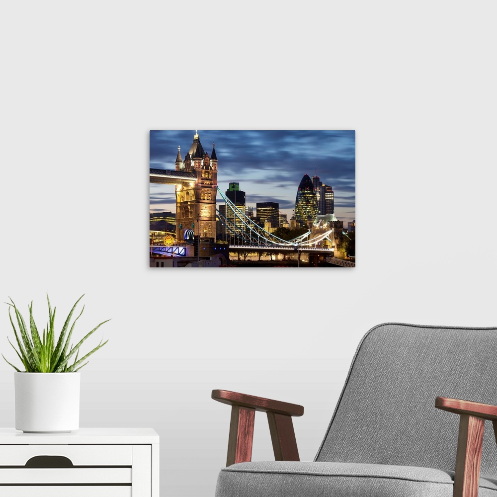 A modern room featuring Tower Bridge and the City of London at night, London, England, UK