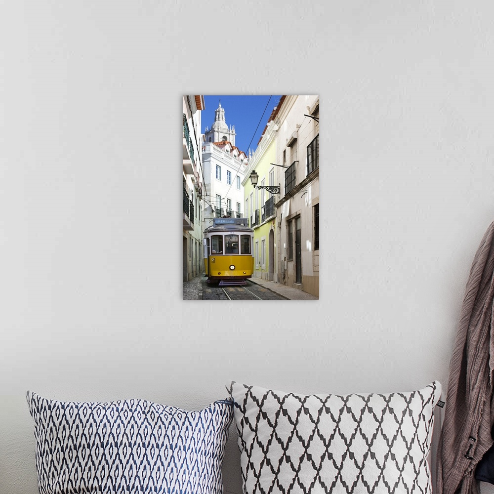 A bohemian room featuring Tram along Rua das Escolas Gerais with tower of Sao Vicente de Fora, Lisbon, Portugal