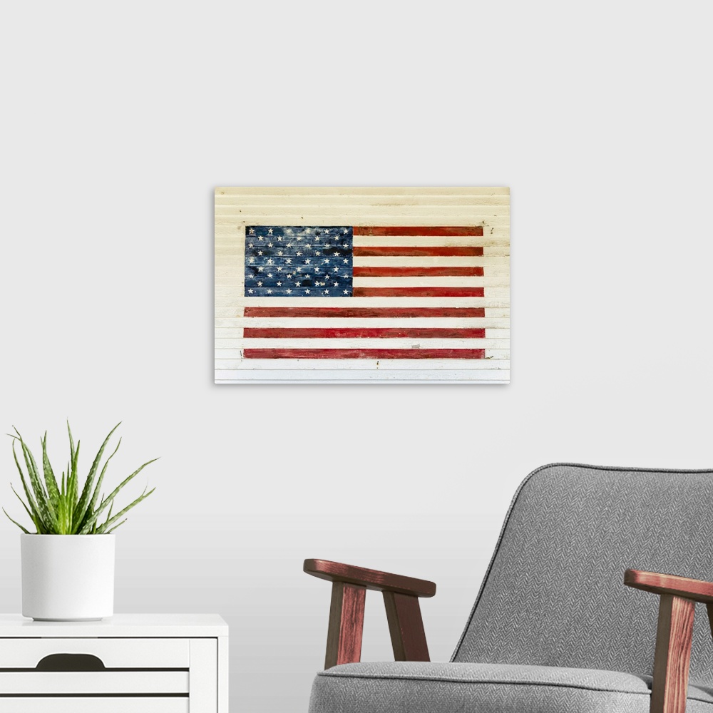 A modern room featuring US Flag painted on the side of a wooden building in the historic area of Chatham, Massachusetts, ...