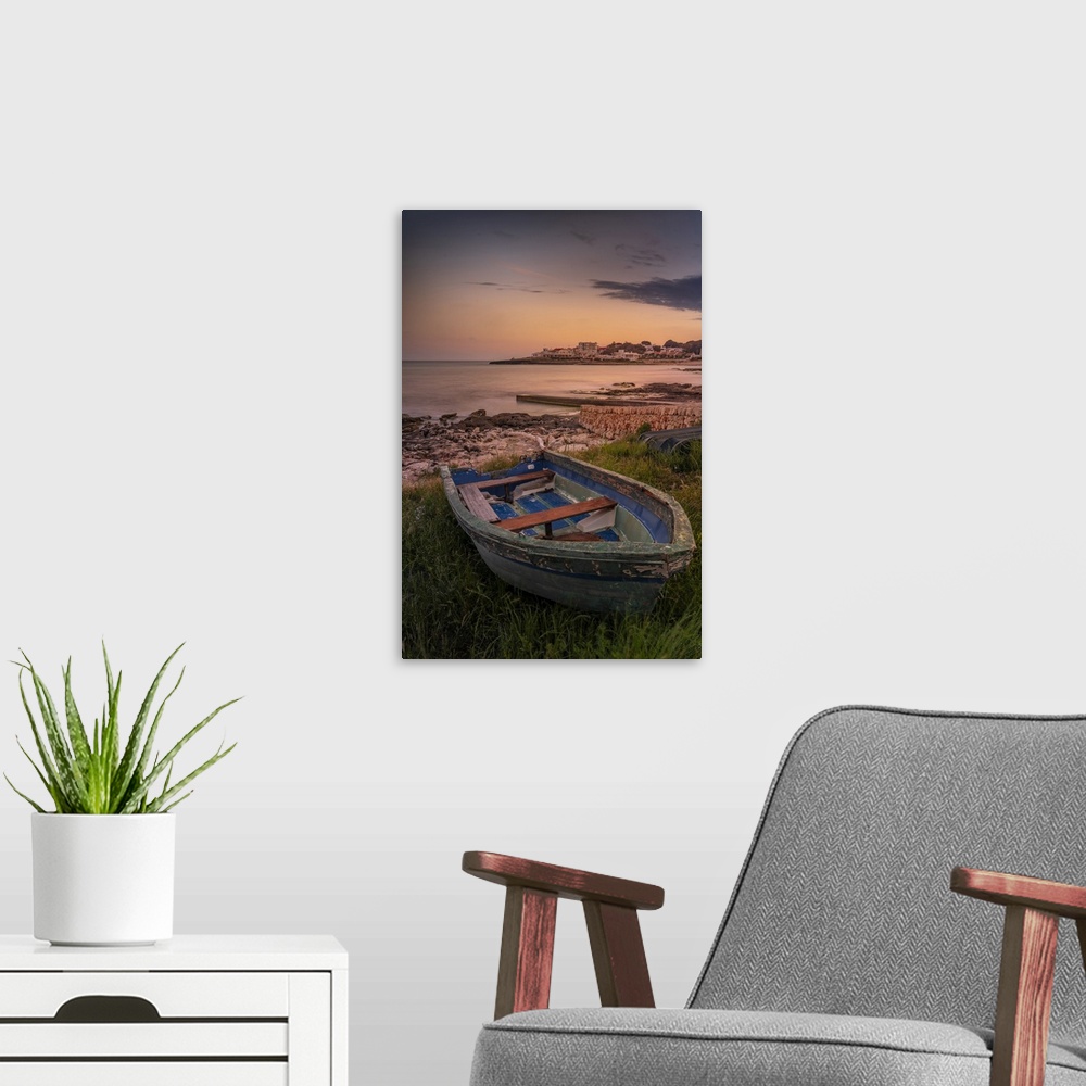 A modern room featuring View of Playa Punta Prima and rowing boat at dusk, Punta Prima, Menorca, Balearic Islands, Spain,...