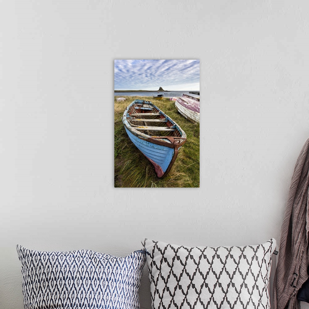 A bohemian room featuring View towards Lindisfarne Castle with an old blue and red fishing boat in the foreground, Lindisfa...