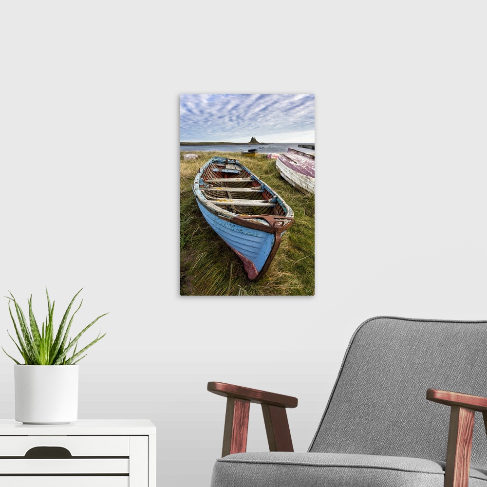 A modern room featuring View towards Lindisfarne Castle with an old blue and red fishing boat in the foreground, Lindisfa...