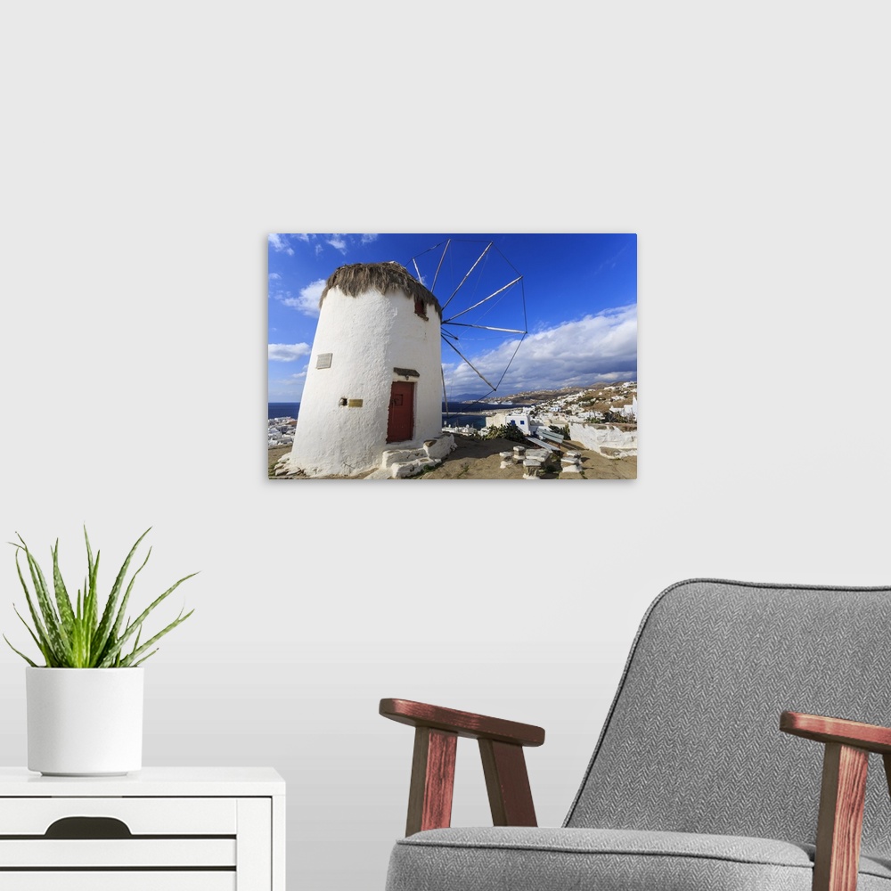 A modern room featuring Whitewashed windmill, view of Mykonos Town and cruise ships in distance, Mykonos, Cyclades, Greek...