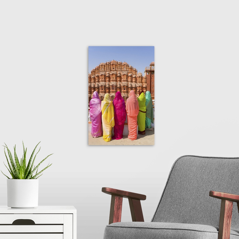 A modern room featuring Women in bright saris in front of the Hawa Mahal (Palace of the Winds), built in 1799, Jaipur, Ra...