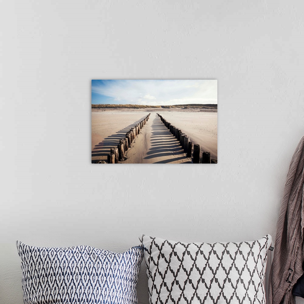 A bohemian room featuring Wooden groynes on a sandy beach, leading to sand dunes, Zeeland, The Netherlands