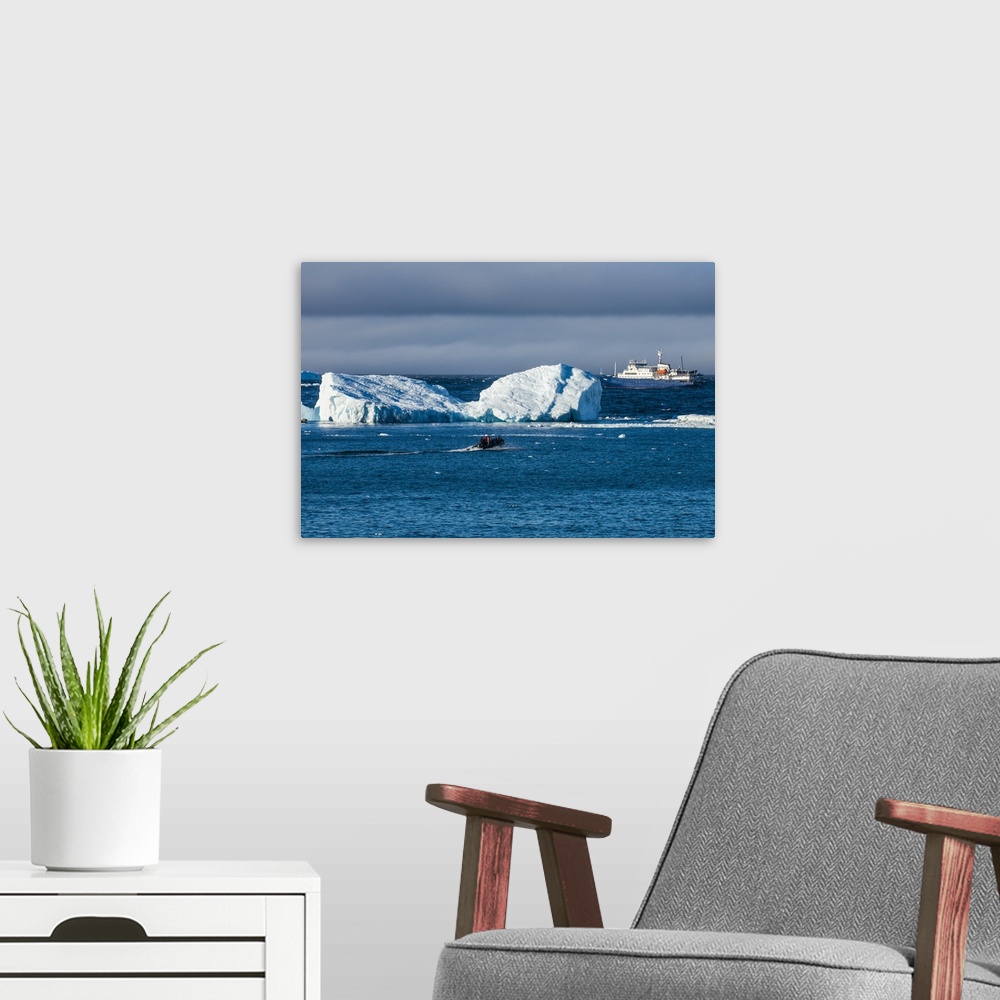 A modern room featuring Zodiac cruising back to a cruise ship anchoring behind an iceberg, Brown Bluff, Antarctica, Polar...