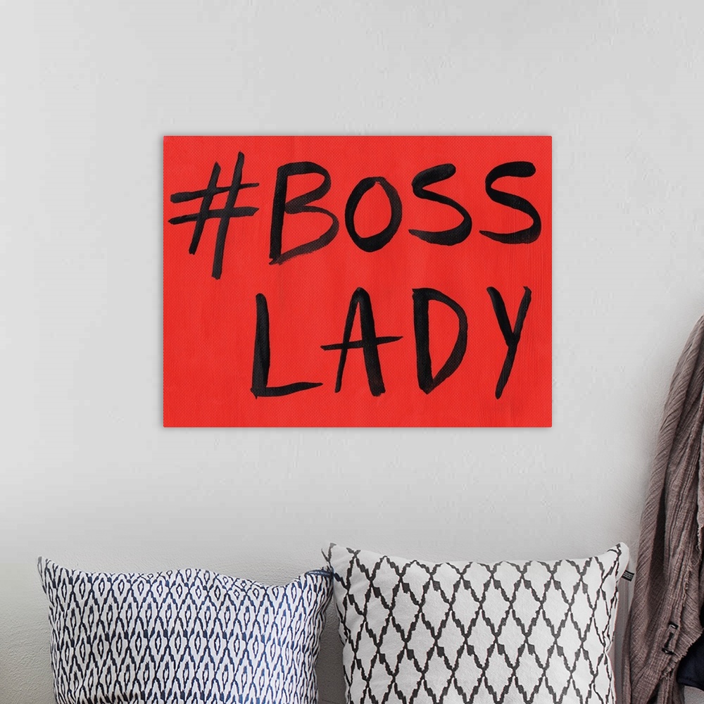 A bohemian room featuring This artwork features the hashtag, "Boss Lady" in black text over a red background.