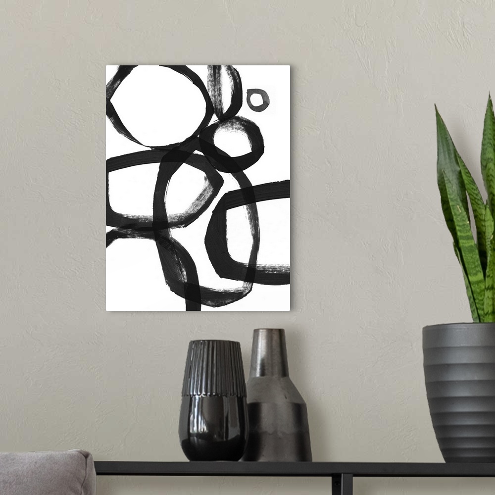 A modern room featuring Abstract artwork of overlapping black rings made of broad brushstrokes on white.