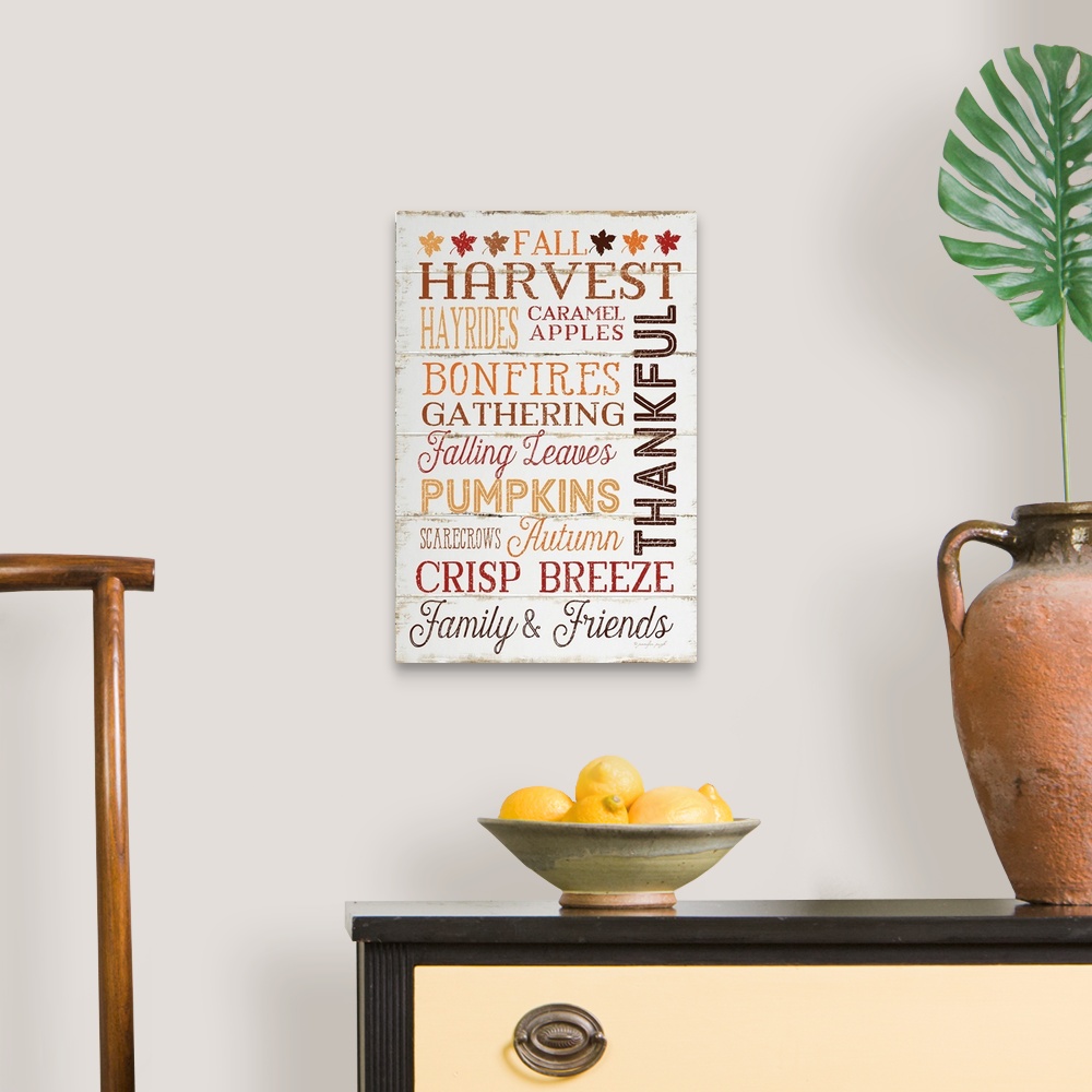 A traditional room featuring Thanksgiving themed typography artwork in festive fall colors against a rustic wooden background.