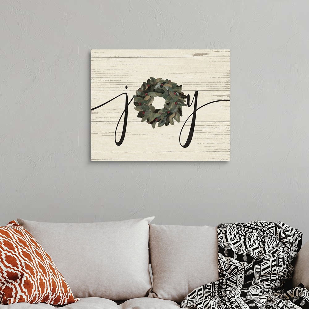 A bohemian room featuring A decorative painting of the word "Joy" with a wreath on a wood paneled background.