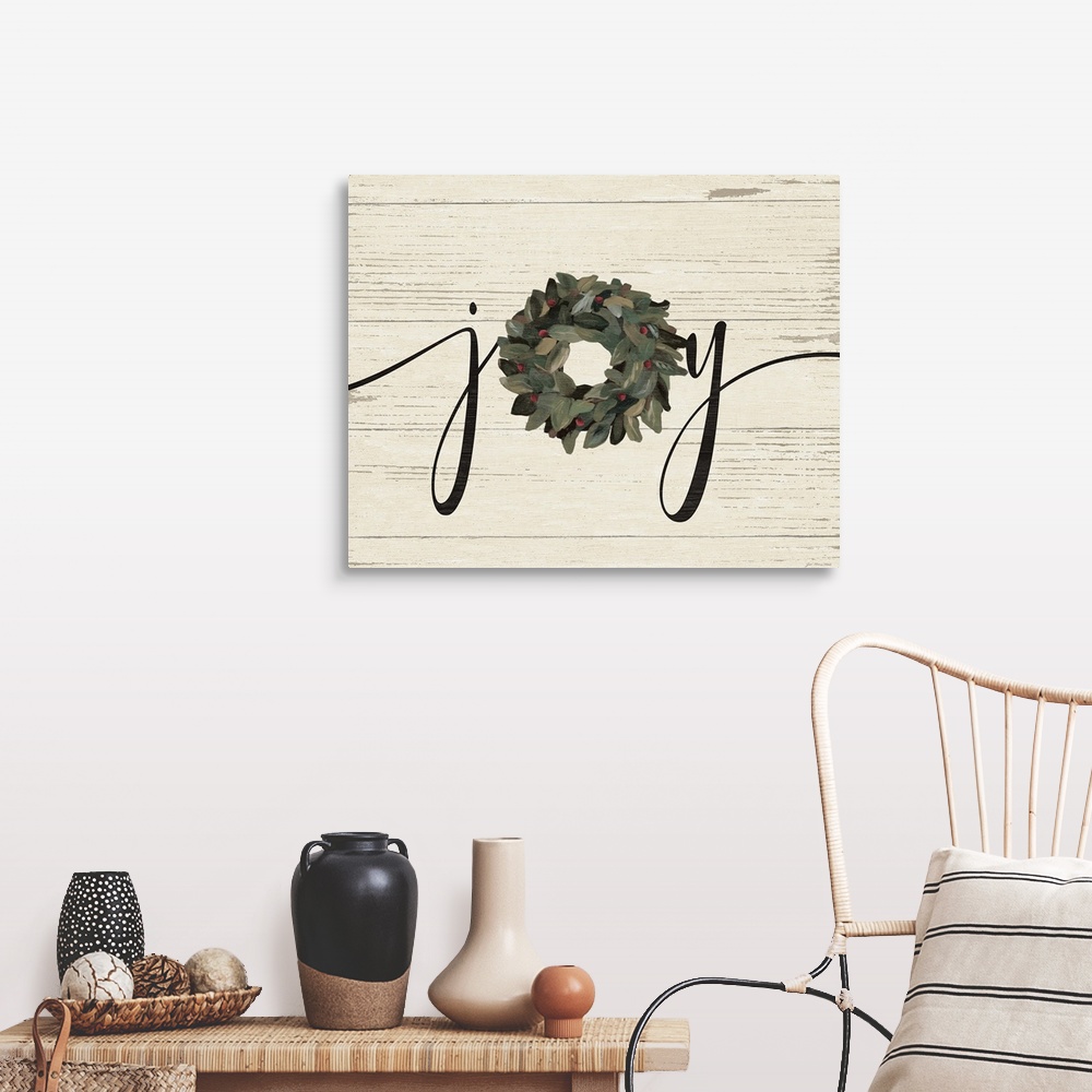 A farmhouse room featuring A decorative painting of the word "Joy" with a wreath on a wood paneled background.
