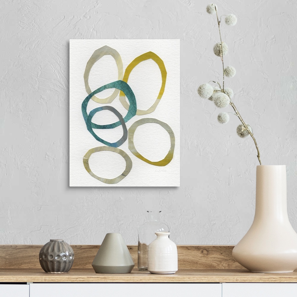 A farmhouse room featuring Abstract contemporary artwork of several overlapping rings of gold and teal, on an off-white back...