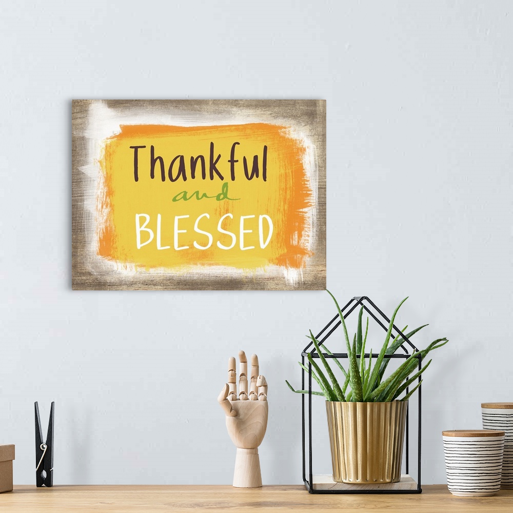 A bohemian room featuring Thanksgiving typography artwork with a painted wooden board effect in yellow and orange.
