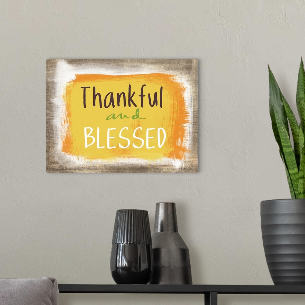 A modern room featuring Thanksgiving typography artwork with a painted wooden board effect in yellow and orange.