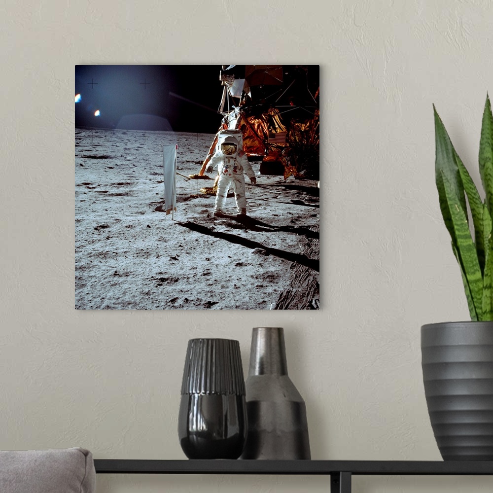 A modern room featuring Apollo 11 astronaut Edwin \Buzz\" Aldrin walks on the surface of the Moon next to the lunar modul...